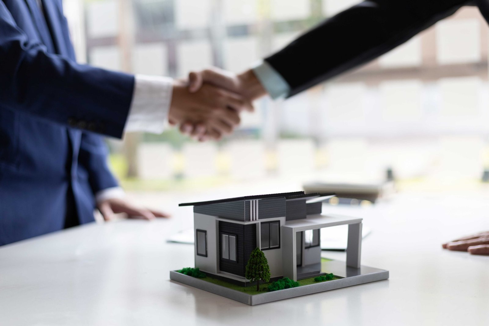 Asesor inmobiliario y cliente estrechando manos para celebrar la venta de una casa en Puebla